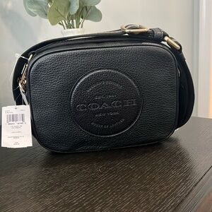 New with tags COACH black and silver crossbody bag with gold hardware.